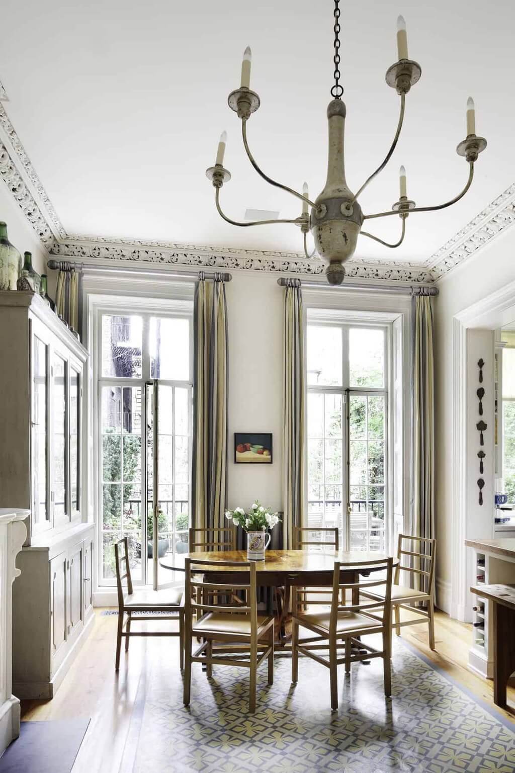 A dining room with a chandelier and chairs.