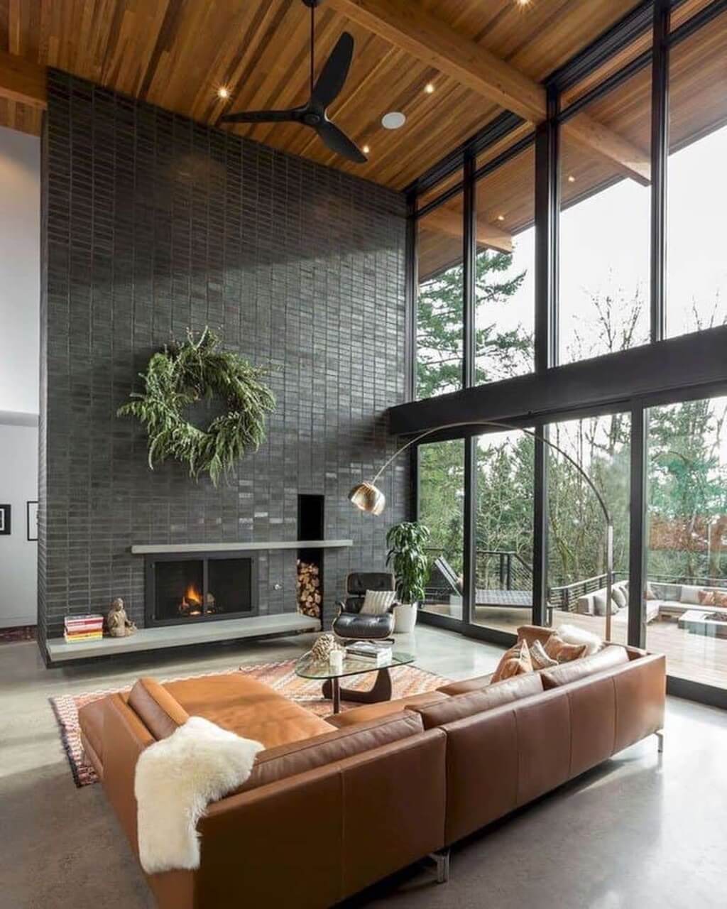 A modern living room with a fireplace and large windows.