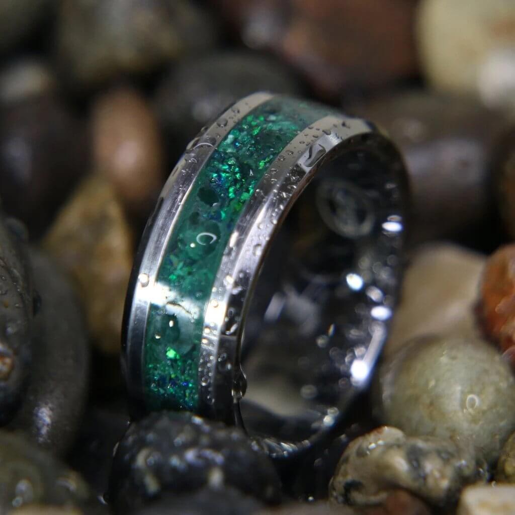 A wedding band with a green and silver ring
