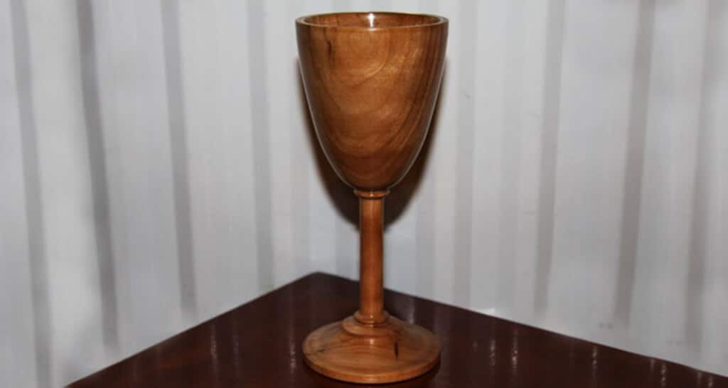 A wooden cup sitting on top of a wooden table
