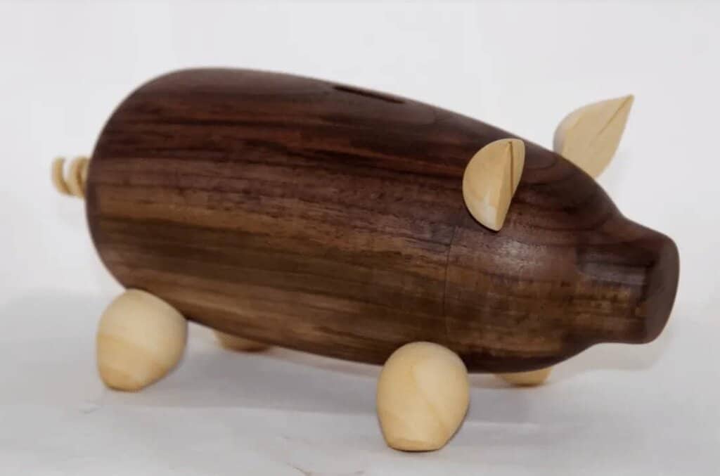 A wooden toy of a pig with two small wheels
