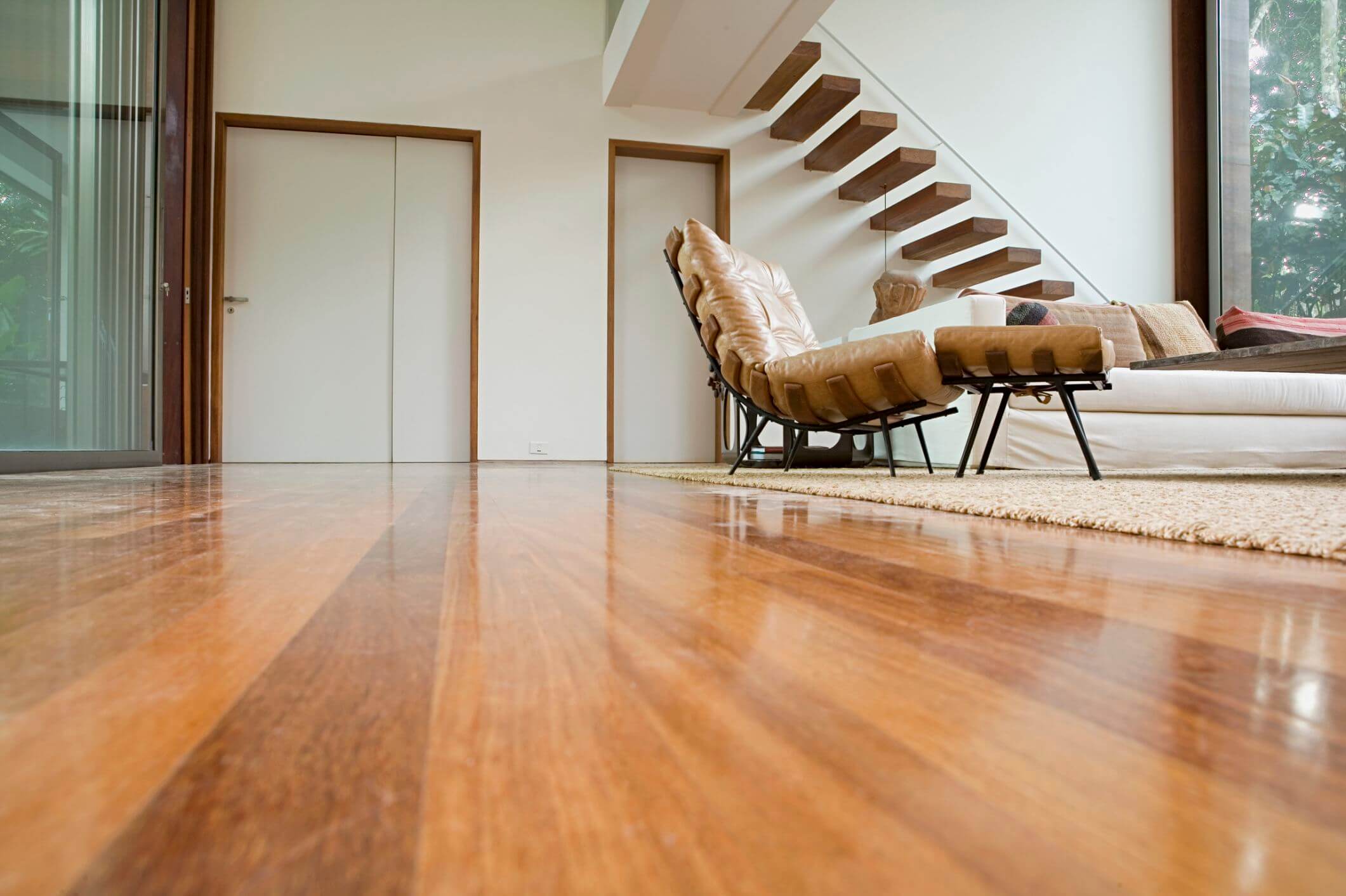 A living room with hard wood floors and a stair case
