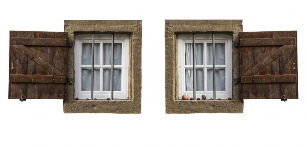 A pair of windows with wooden shutters on a white background
