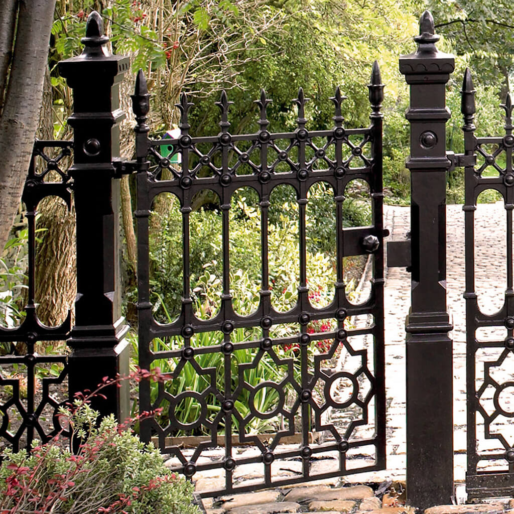 A black gate with a bird on top of it
