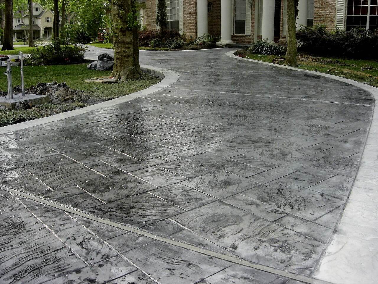 A driveway that has been cleaned and has a tree in the middle of it
