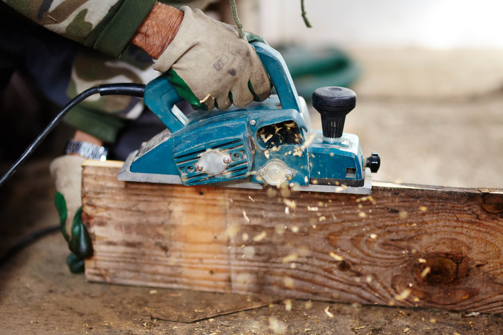 A person using a power tool on a piece of wood
