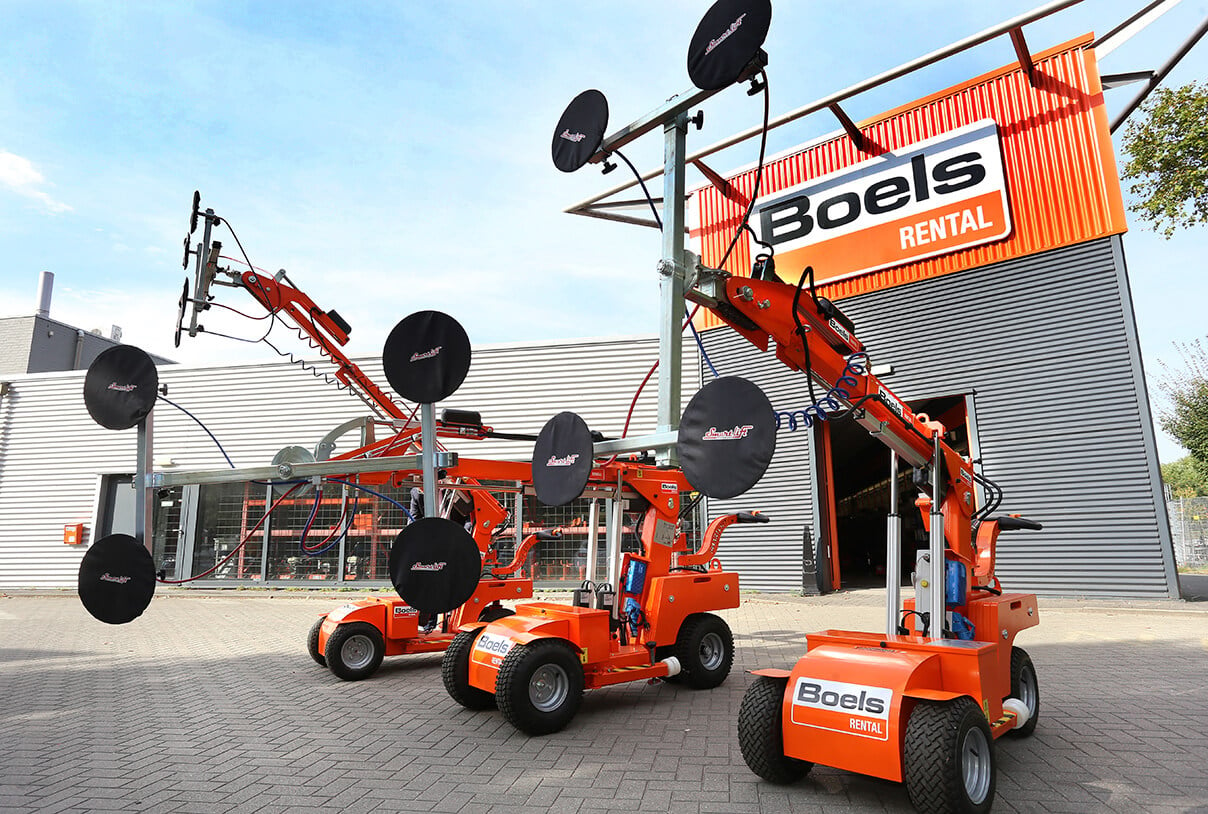 A couple of orange trucks parked in front of a building
