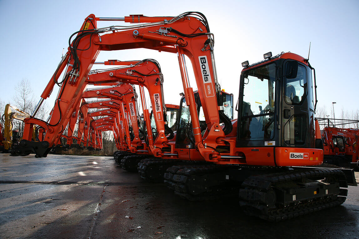 A row of orange machines sitting next to each other
