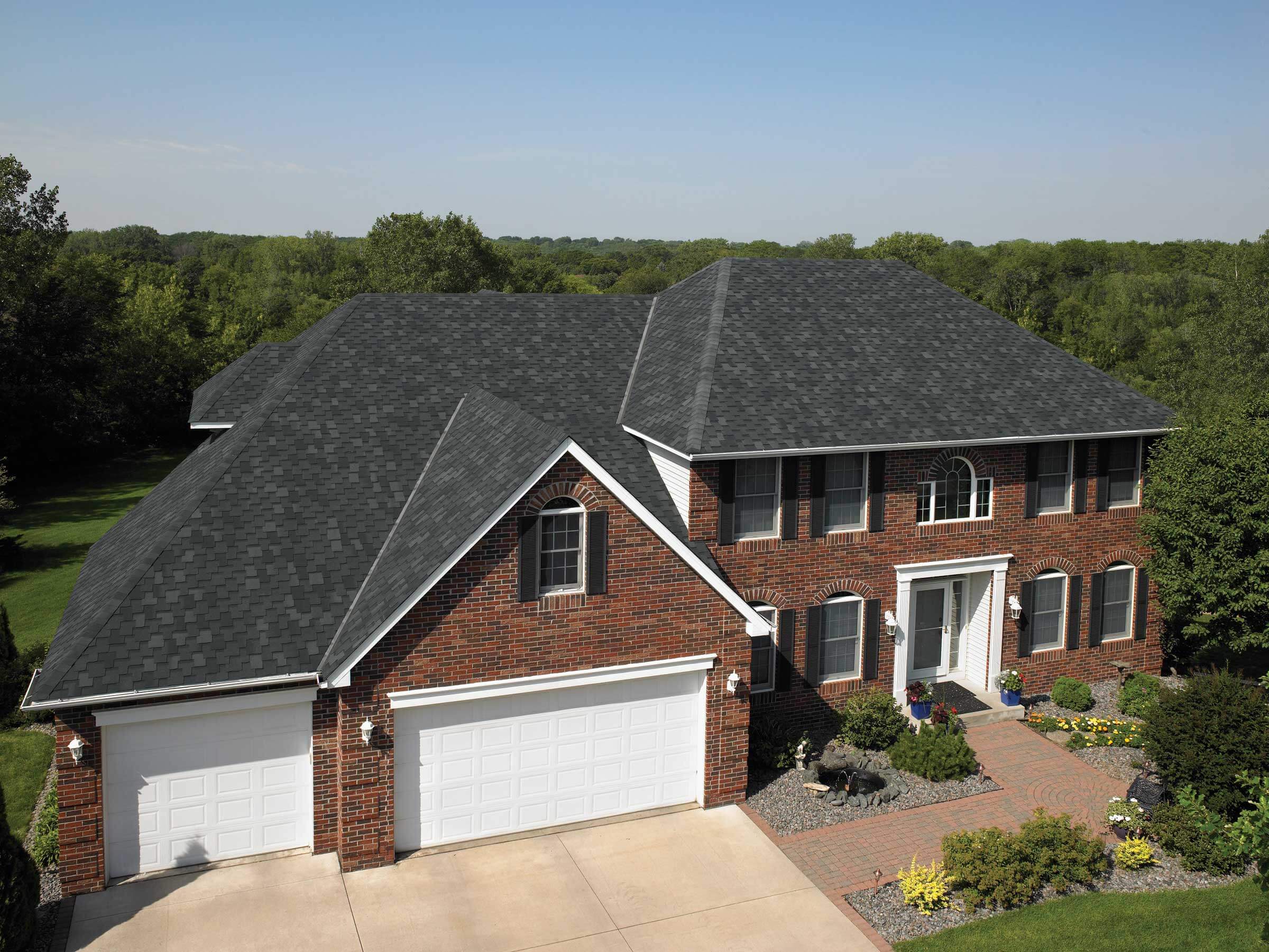 A large brick house with two garages and a driveway
