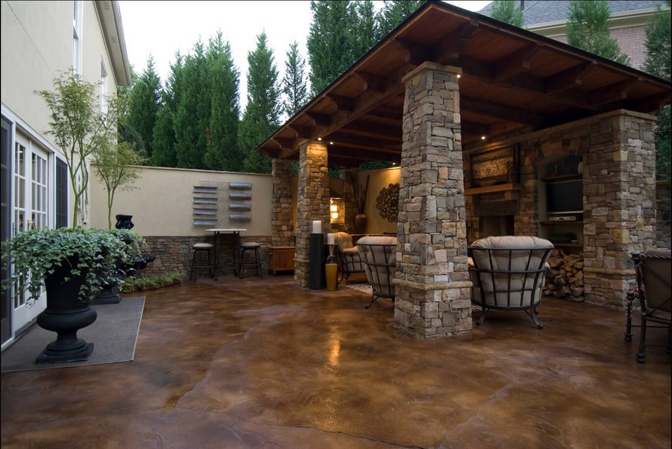 A patio with stone pillars and a grill: Stain Concrete Floors