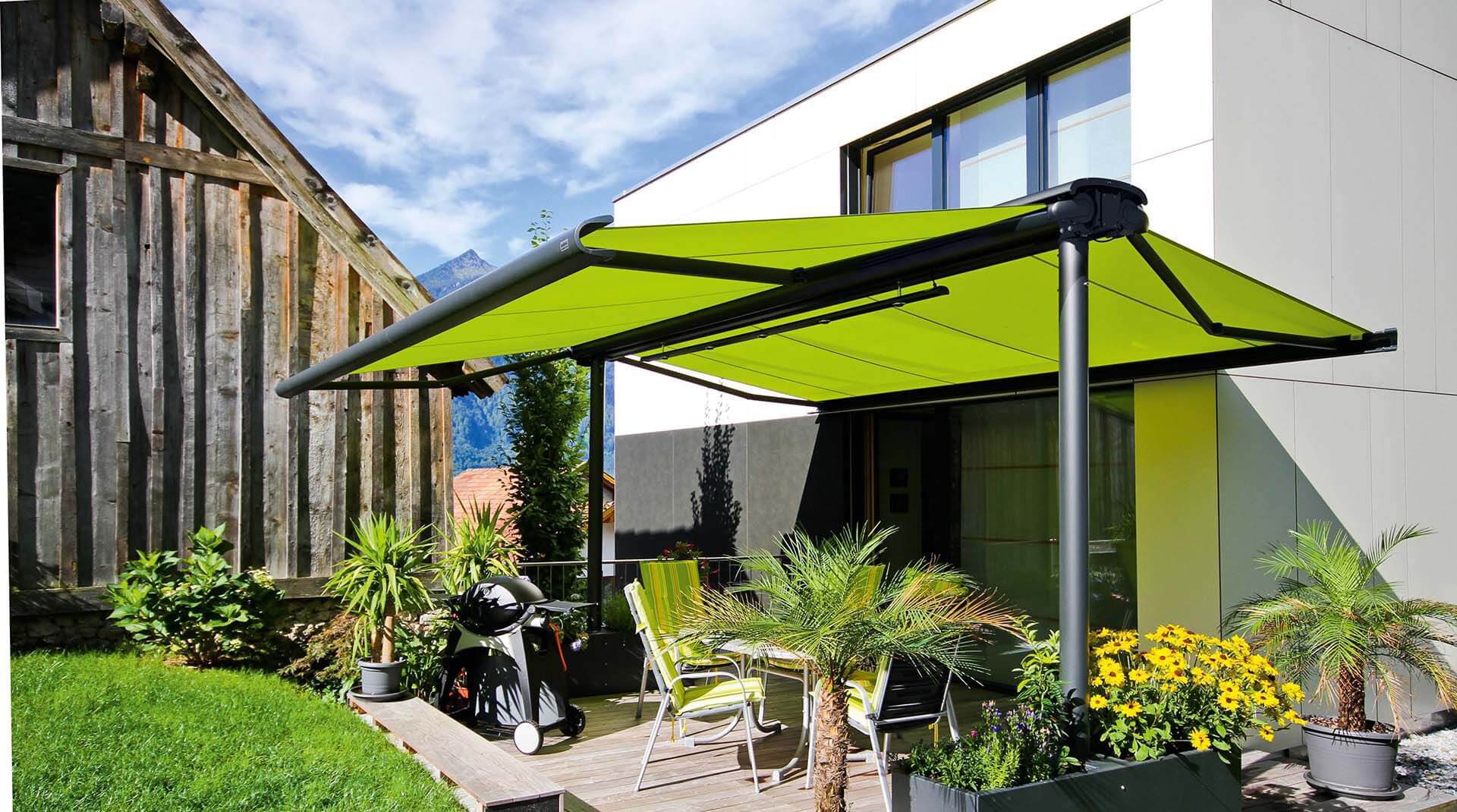 A patio with a table and chairs under a green umbrella
