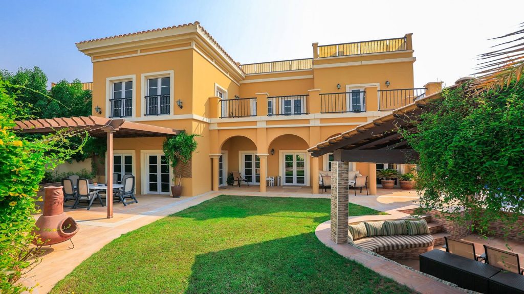 A large yellow house with a covered patio
