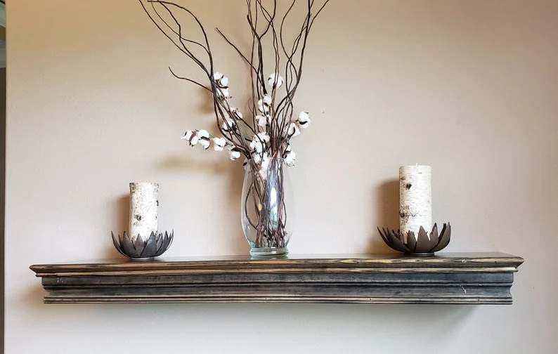 A shelf with two vases and a vase with flowers on it
