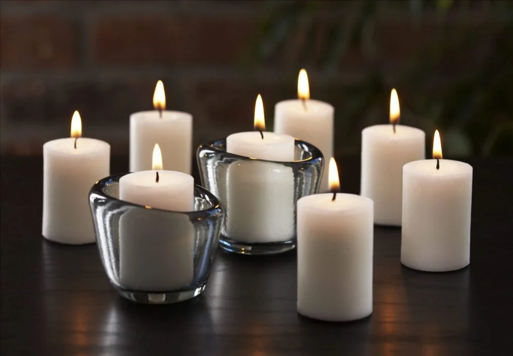 A group of white candles sitting on top of a table
