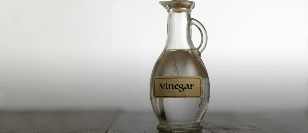 A bottle of vinegar sitting on a table
