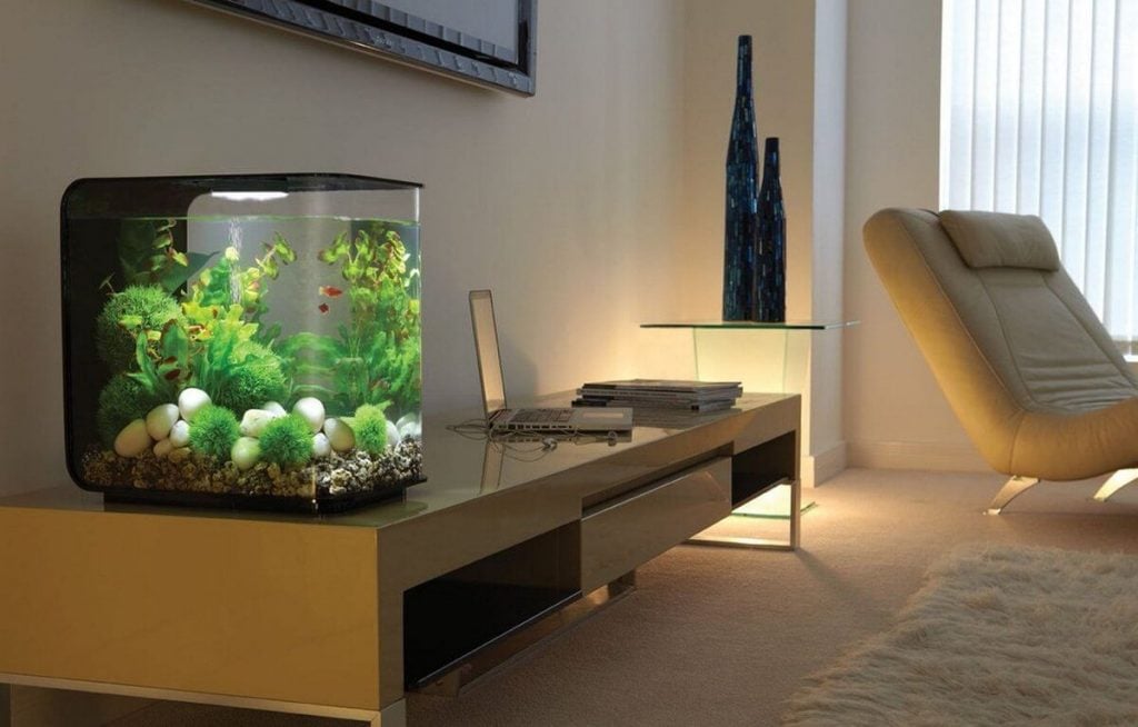 A fish tank sitting on top of a table next to a couch
