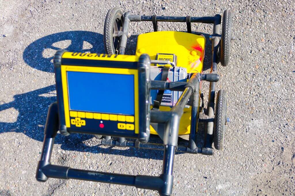 A small yellow and black  Ground Penetrating Radar on the ground
