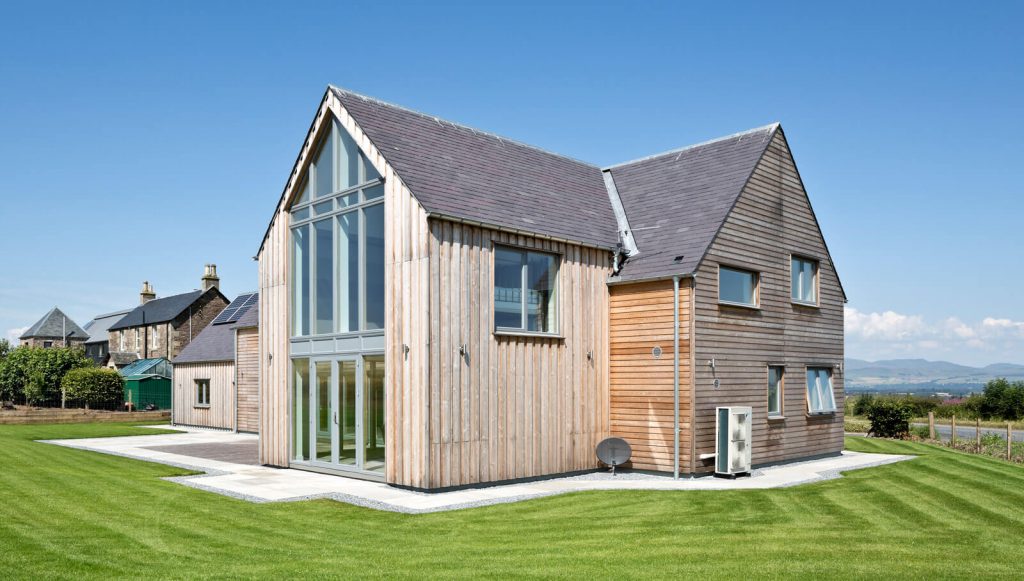 A large wooden building sitting on top of a lush green field
