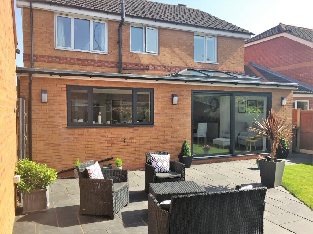 A patio with chairs and a table in front of a house ideas