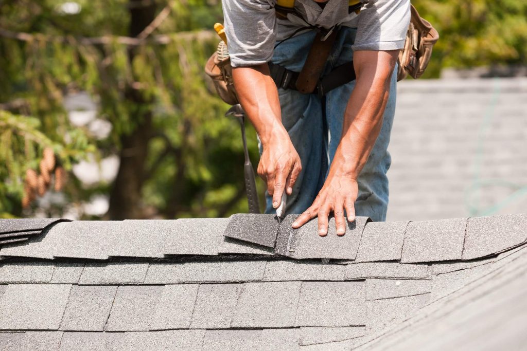 A man is working on the roof of a house
