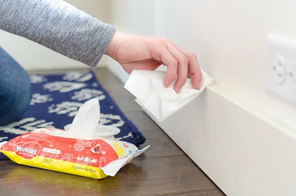 cleaning baseboards with  with Baby Wipes