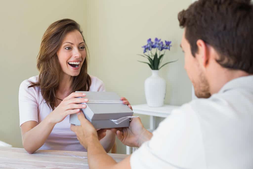 A man giving a woman a
 handmade valentine gift