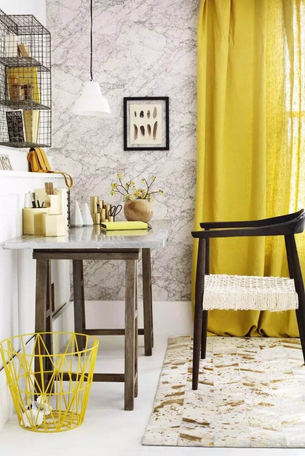 A room with a chair, table and yellow curtains
