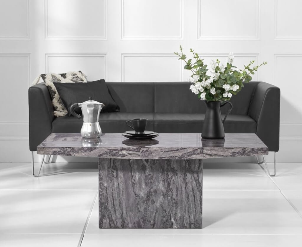 A marble coffee table with two vases on top of it
