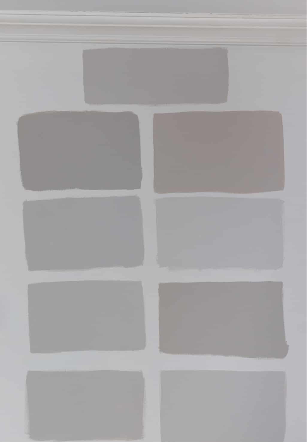 A white wall with a bunch of gray paint swatches
