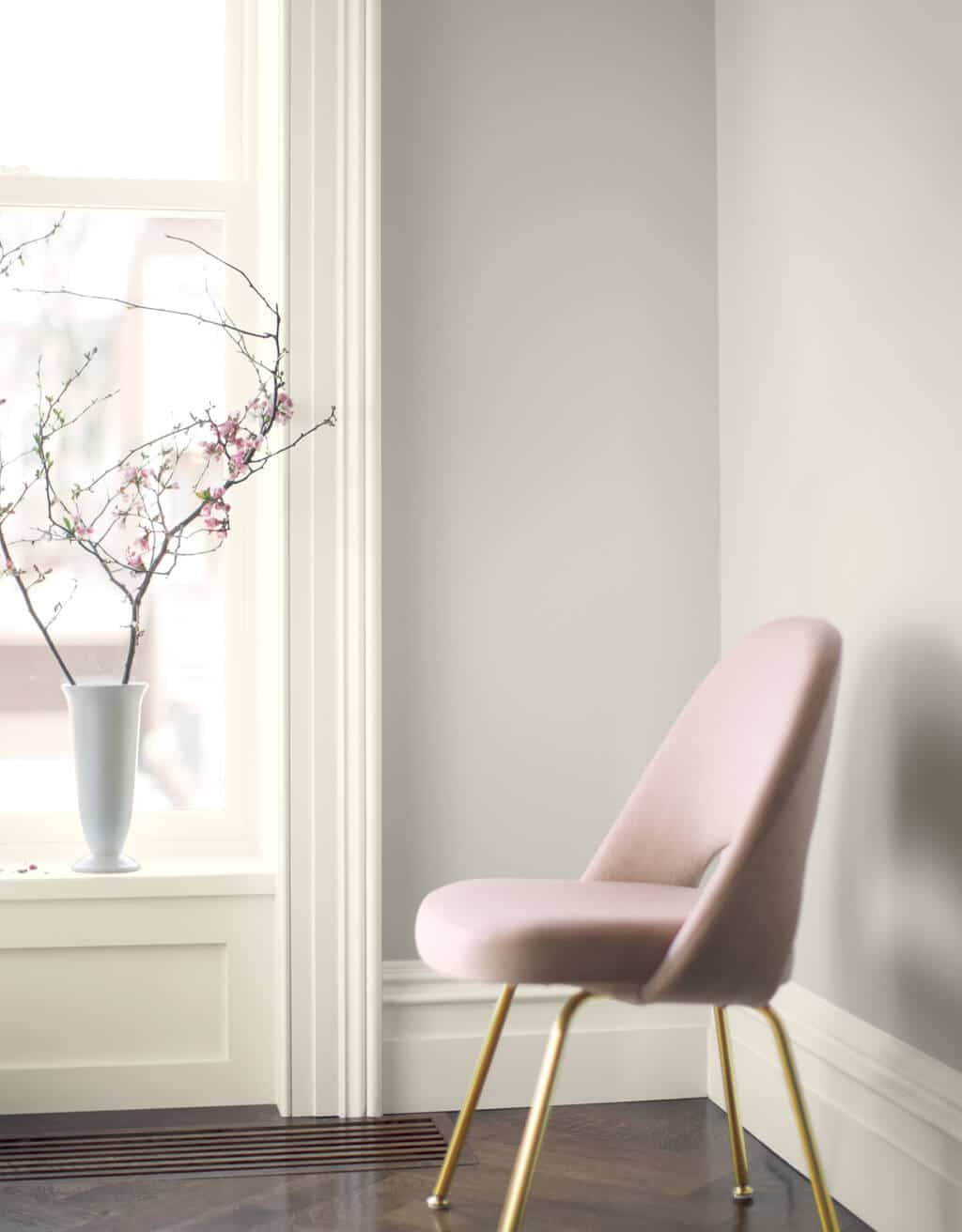 A pink chair sitting in front of a window
