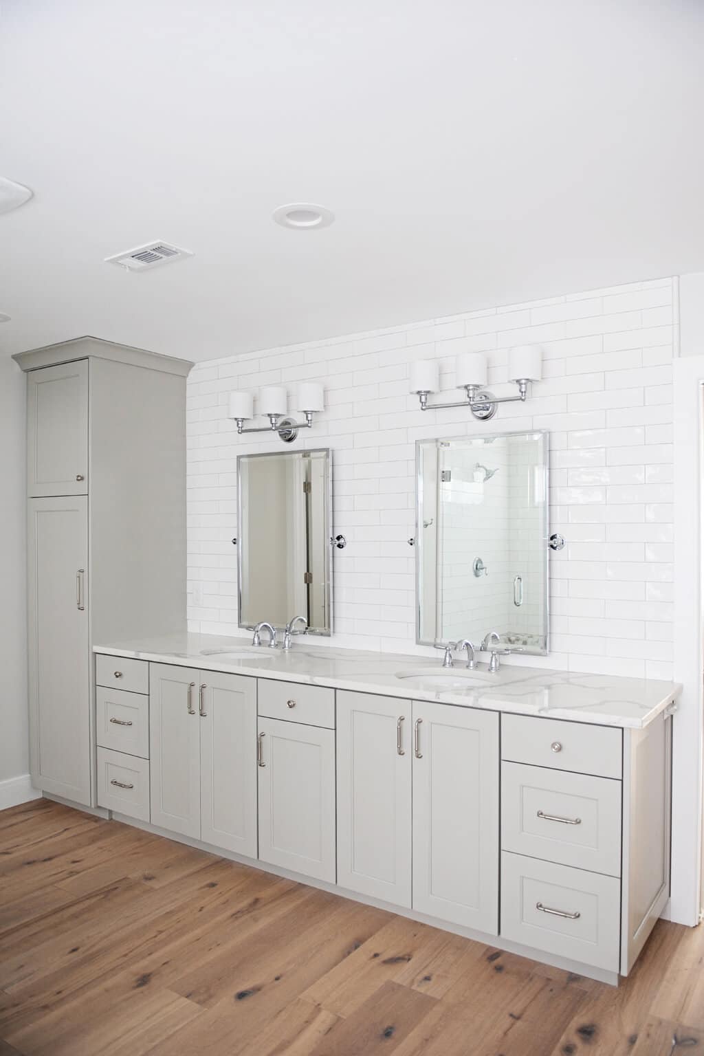 A bathroom with two sinks and two mirrors

