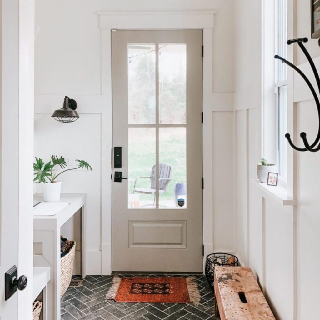 A white door with a bench in front of it
