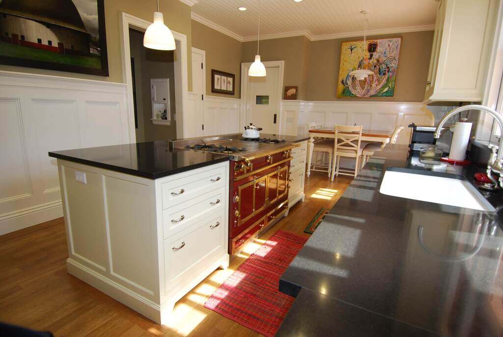 A kitchen with a center island and a stove top oven
