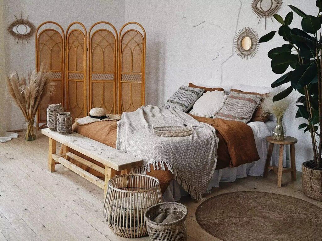 A bedroom with a bed and a plant in the corner
