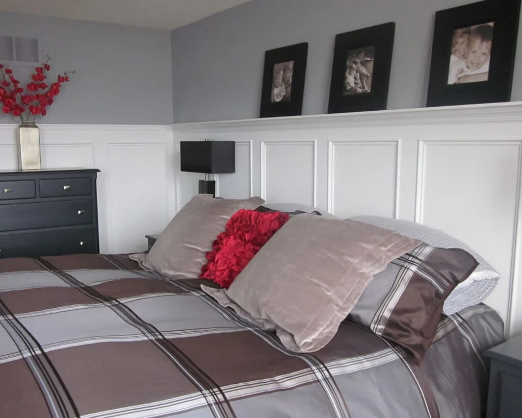 A bedroom with a bed, dresser, and pictures on the wall
