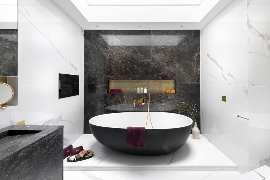 A bathroom with a black and white bath tub
