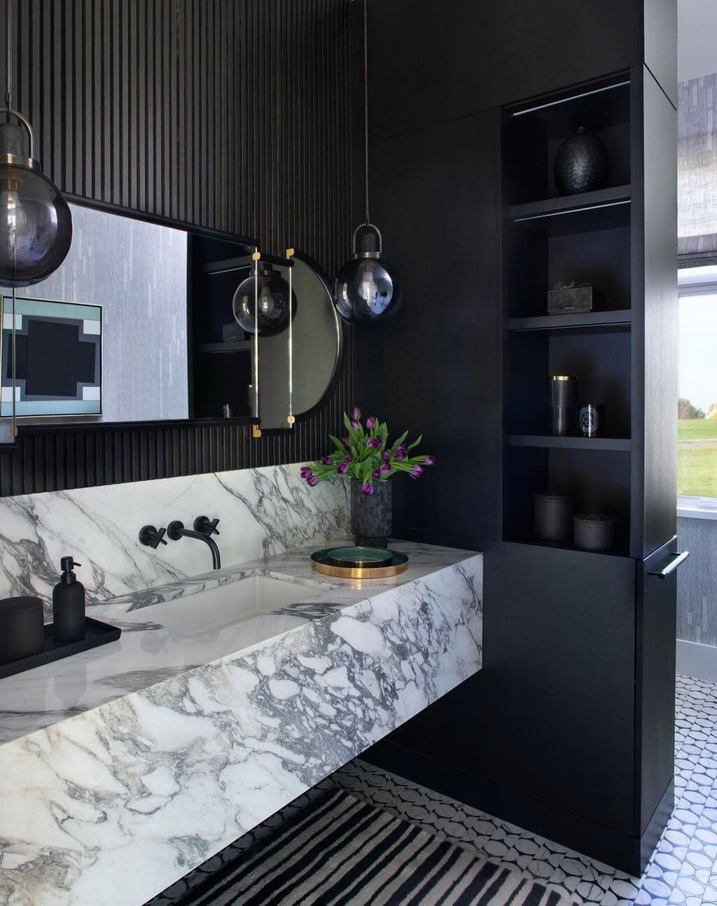 A black and white bathroom with a marble sink
