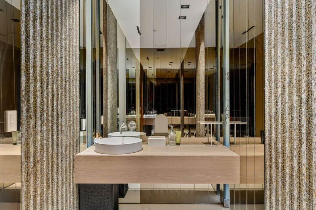 A bathroom with a large mirror and a sink
