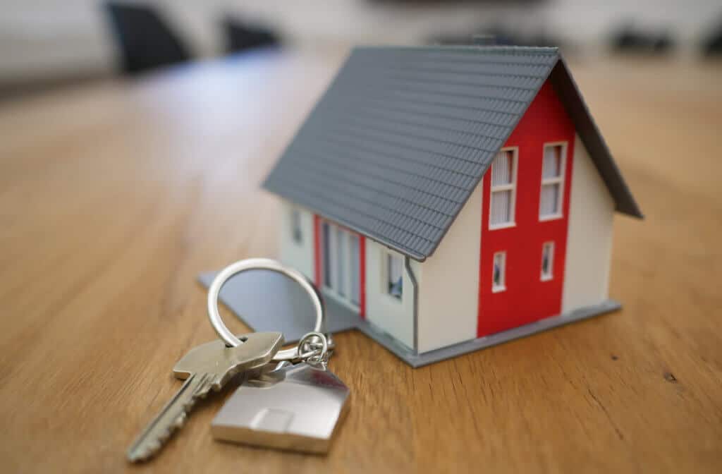 A house model with a key on a table
