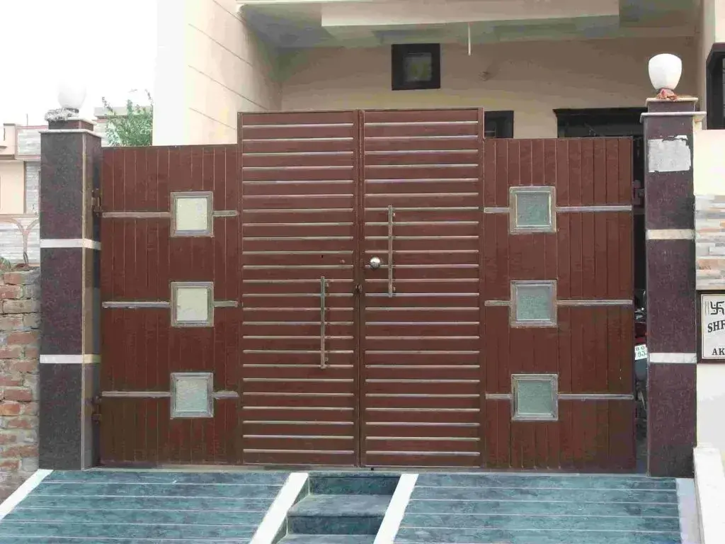 A wooden gate with glass inserts in front of a house
