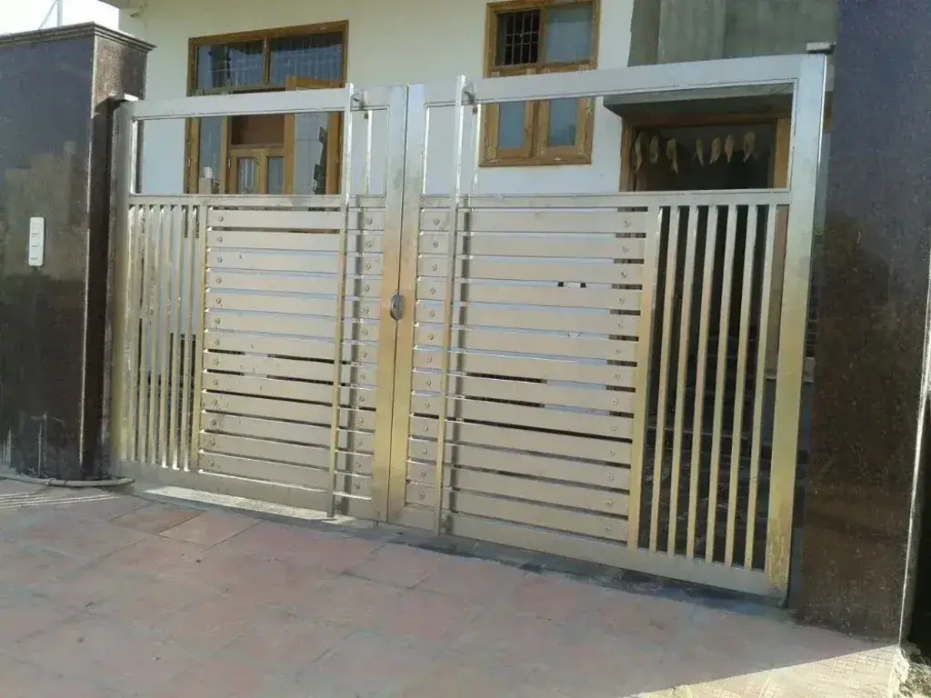 A large metal gate with two windows in front of a building
