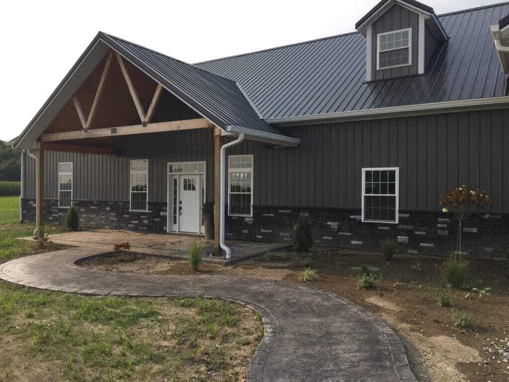 A large gray house with a metal roof
