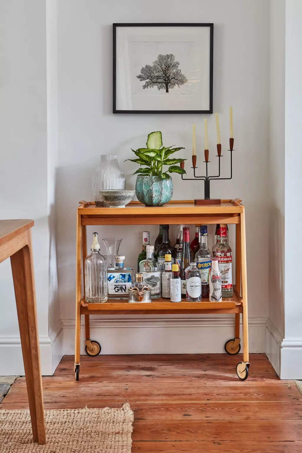 A bar cart with liquor bottles on it in a living room
