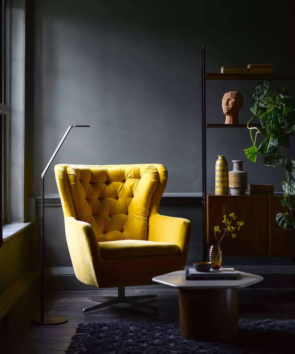 A living room with a yellow chair and a white coffee table
