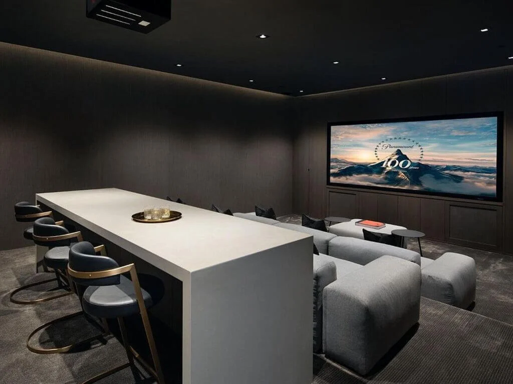 A home theater with a large screen and chairs
