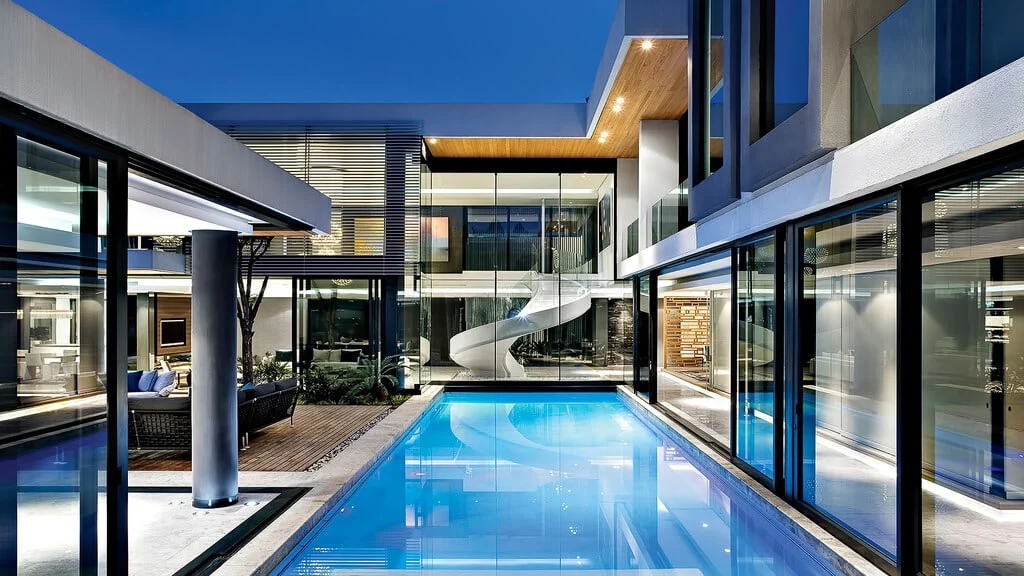 A large swimming pool in front of a modern house
