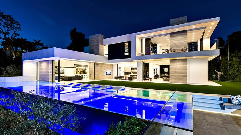A modern house with a swimming pool at night
