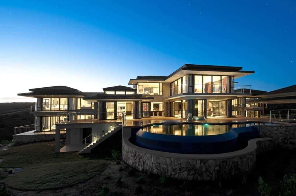 A large house with a pool in front of it
