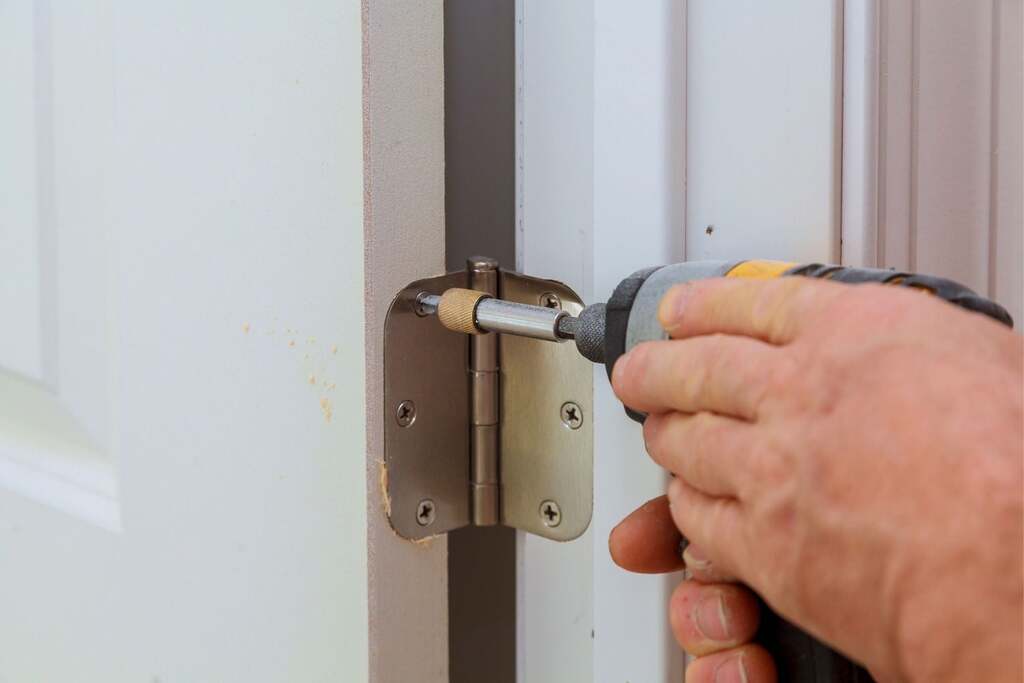 A person using a screwdriver to open a door