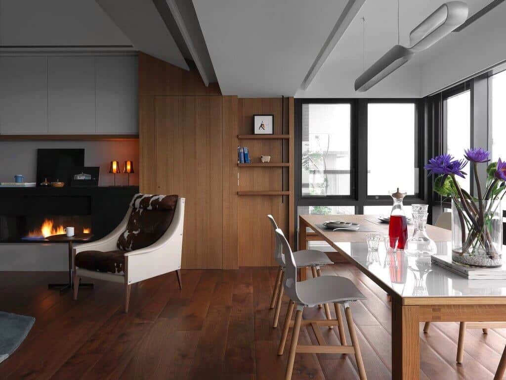 A dining room table with chairs and a fireplace in the background
